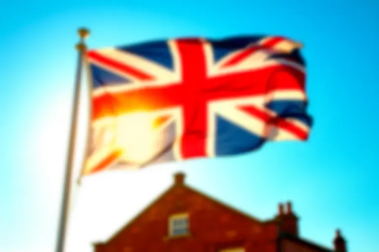 Union Jack flag waving over a colonial American building