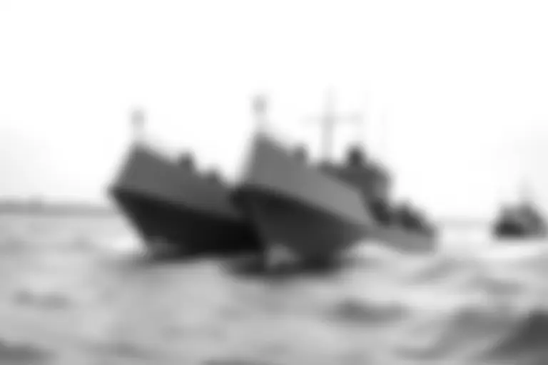 Military landing craft approaching a beach