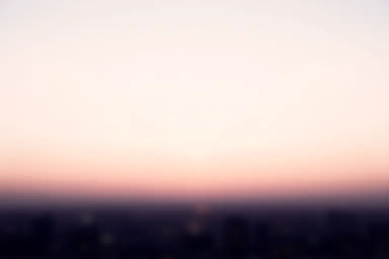 Empty sky above a city at dawn with no birds visible