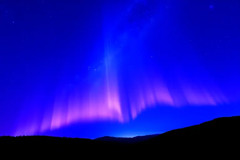 Night sky filled with glowing web-like filaments of dark matter connecting galaxies