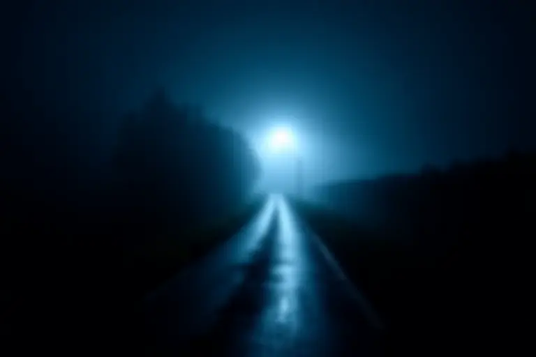 A dark road at night with fog