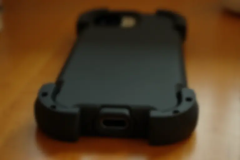 Phone in a thick rubber case attached to a wrist strap