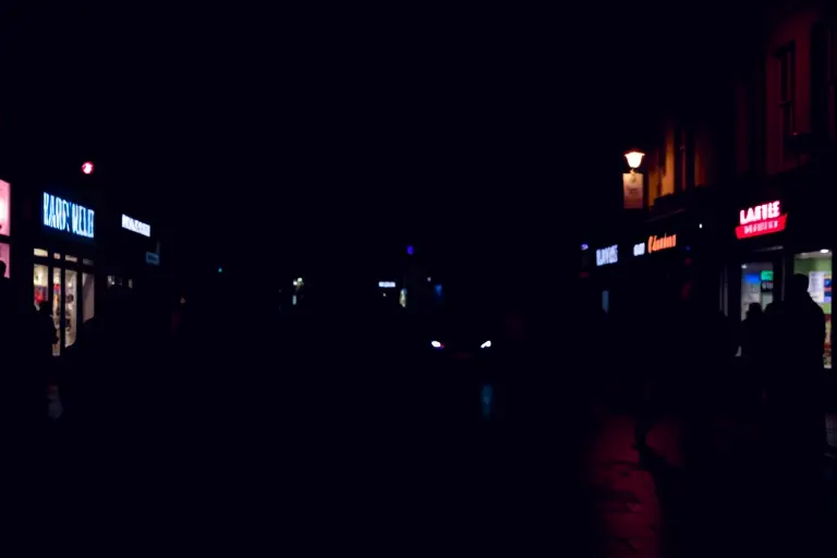 Busy high street with shops and restaurants lit up at 3am