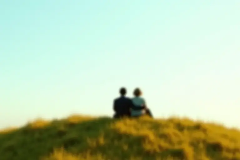 Two people sitting together in a beautiful virtual landscape that looks perfectly real